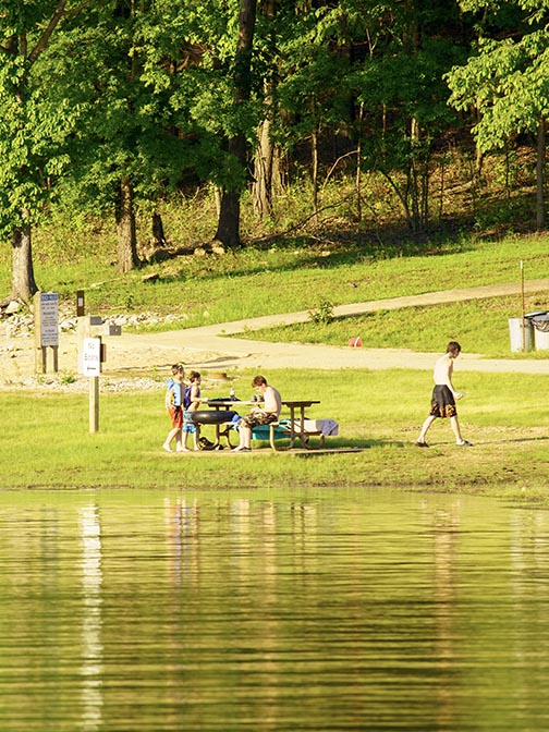 Image of 4 children around a picnic table setting up their fishing rods.